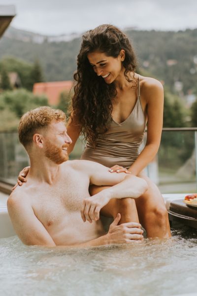 Young couple enjoying in outdoor hot tub on vacation Young couple enjoying in outdoor hot tub on vacation